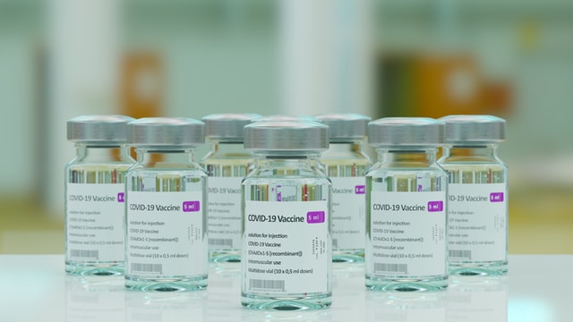 clear glass vials labelled covid vaccine